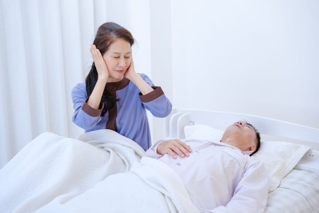 いびきで耳を塞ぐ女性